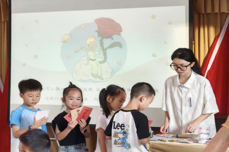 (志愿者為小朋友發放精美小獎品。李雯倩 供圖)